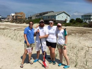 Fort Fisher Aquarium staff planting baby sea oats to help build future sand dunes on Oak Island